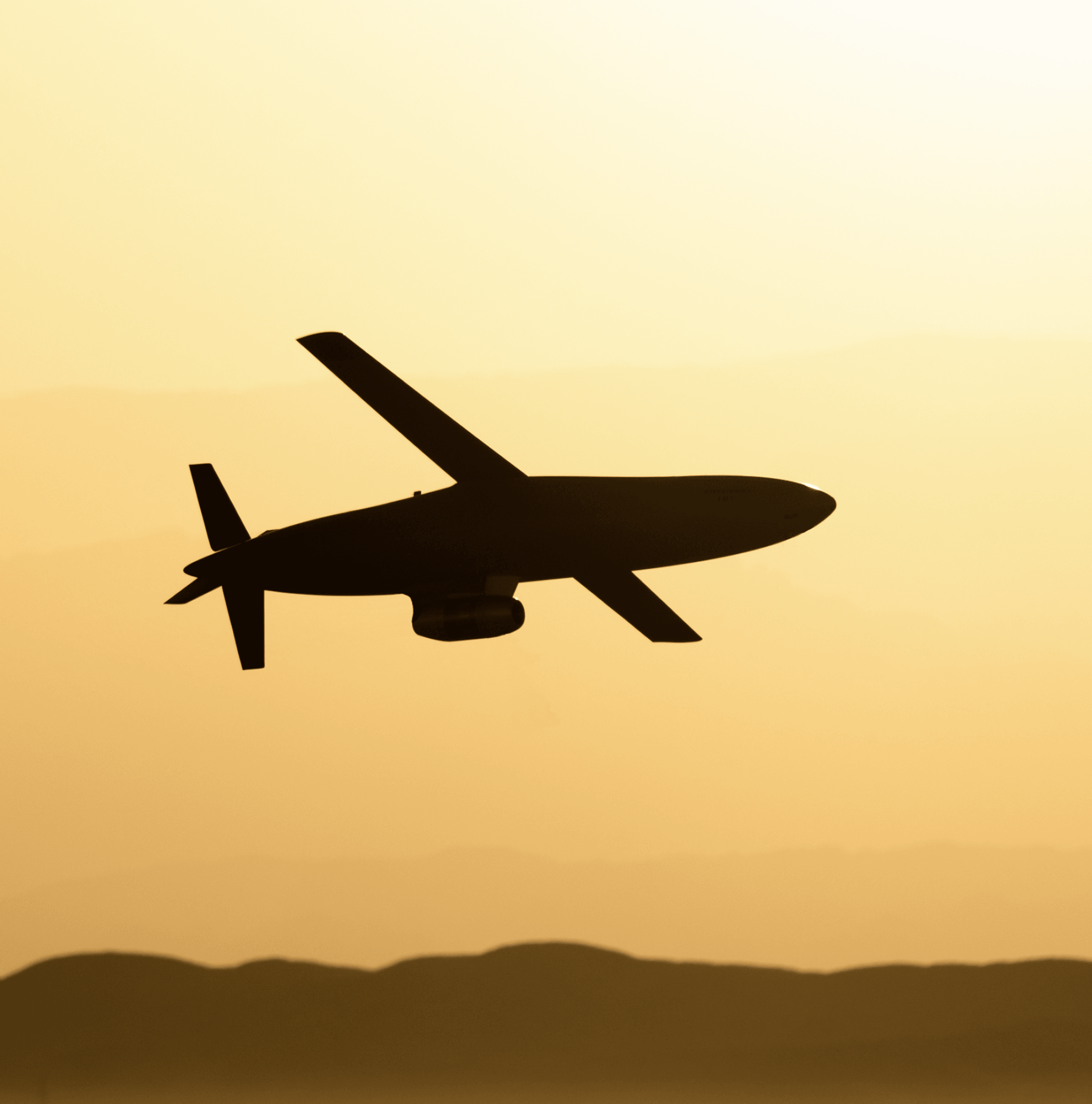 A Covenant cruise missile in silhouette against a hazy amber sunset, above a low ridgeline.